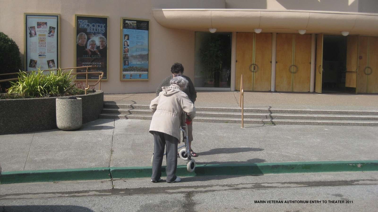 A pedestrian facing steps at the auditorium entrance, before the accessibility improvements