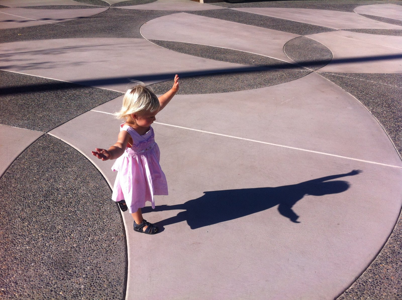 A child playing on the laurel leaf paving of the plaza
